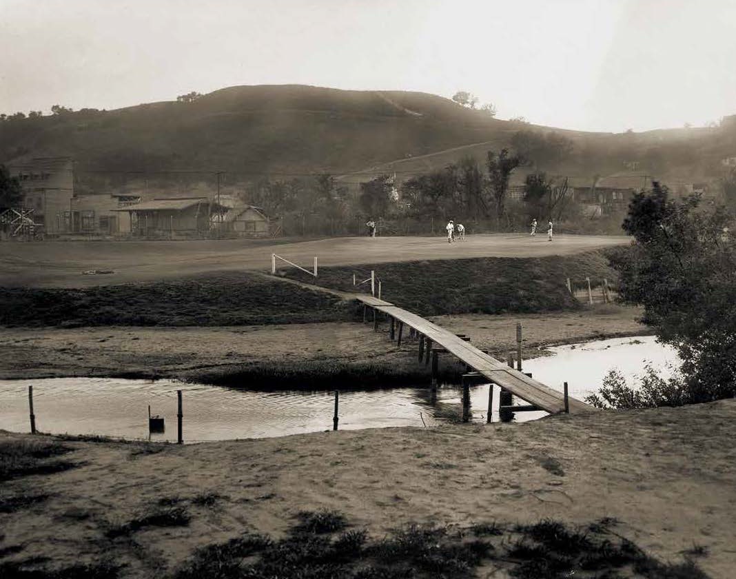 Historic photograph of a footbridge to the green, circa 1925